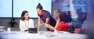 A small group of people at a table in a conference room, discussing software integrations