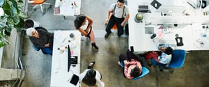 A top down view of an open concept office space with a diverse group of people interacting
