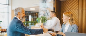 A guest and a hospitality worker interacting at the front desk