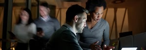 A man and a woman looking at the screen of a tablet