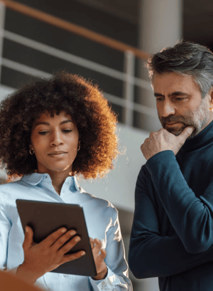 A woman and a man looking at a tablet