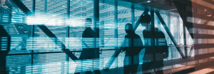 Silhouettes of people walking down an illuminated hallway